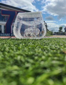 Photograph is of a clear acrylic purse that has "Bills Mafia" engraved inside of a buffalo. Setting for photoshoot is Highmark Stadium, home of the Buffalo Bills.