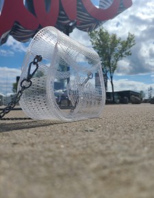 Photograph is of a clear acrylic purse that has "Bills Mafia" engraved inside of a buffalo. Setting for photoshoot is Highmark Stadium, home of the Buffalo Bills.