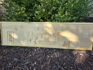 Custom wooden sign showcasing an intricate laser-engraved scene of Buffalo, New York's Theatre District. Each sign is custom framed in polished wood, reflecting the craftsmanship and artistry behind their creation.
