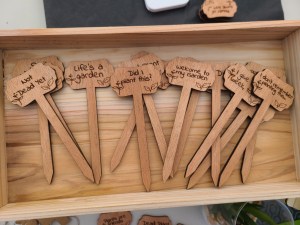 Funny wooden plant stakes with various phrases.