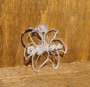 Photograph of clear acrylic lily keychain against wooden background.