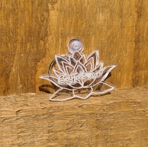 Photograph of Clear Acrylic Lotus Flower Keychain against wooden background